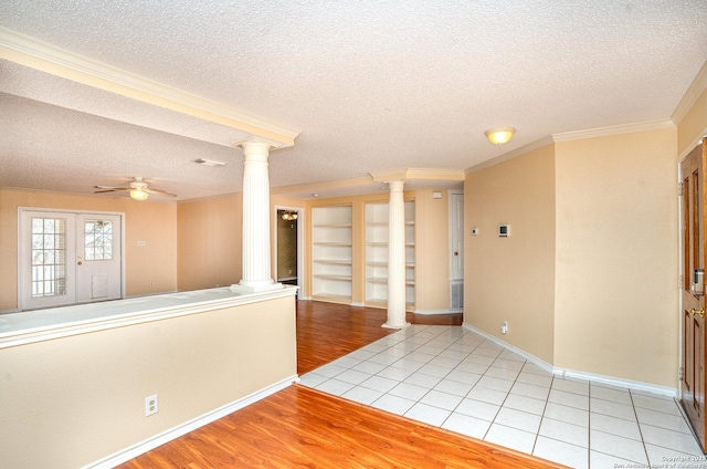 spare room with ornamental molding, light wood-type flooring, ceiling fan, and ornate columns