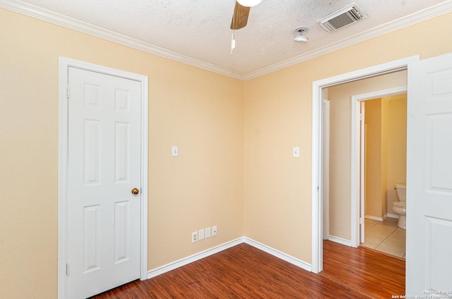 empty room with dark wood-style floors, ceiling fan, a textured ceiling, and visible vents