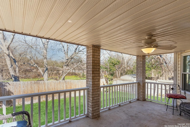 view of patio with ceiling fan, fence, and an outbuilding