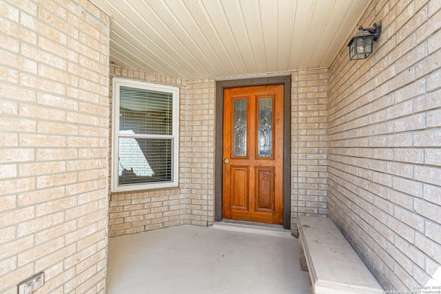 view of exterior entry featuring brick siding