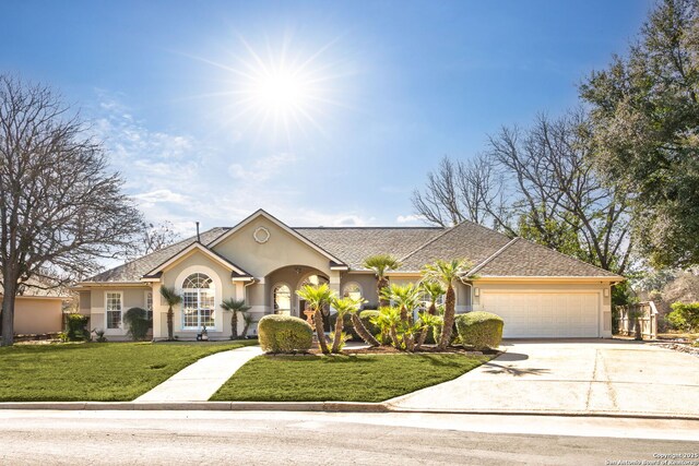 view of front of home with an attached garage, a front lawn, concrete driveway, and stucco siding