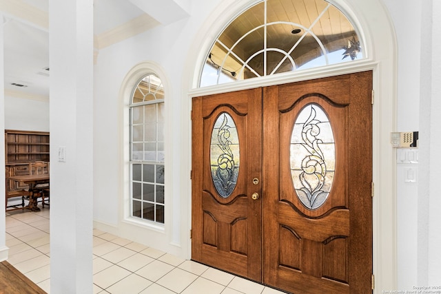 tiled foyer entrance featuring ornamental molding