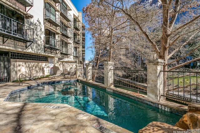 pool with fence and a patio