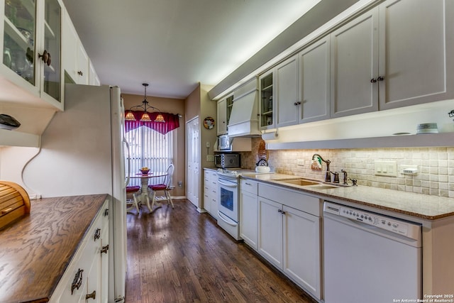 kitchen with white appliances, tasteful backsplash, dark wood-style floors, glass insert cabinets, and a sink