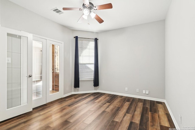 spare room with dark wood-style floors, french doors, visible vents, and baseboards