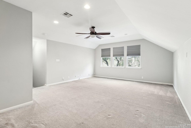 carpeted empty room featuring lofted ceiling, ceiling fan, recessed lighting, visible vents, and baseboards