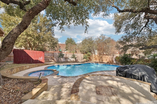 view of swimming pool with a patio area, grilling area, a fenced backyard, and a pool with connected hot tub