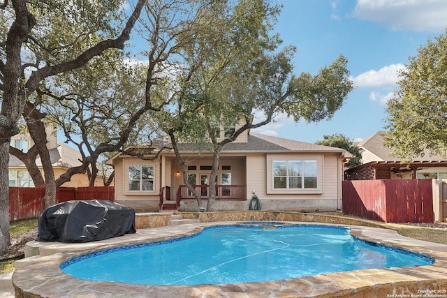 back of house with fence and a fenced in pool