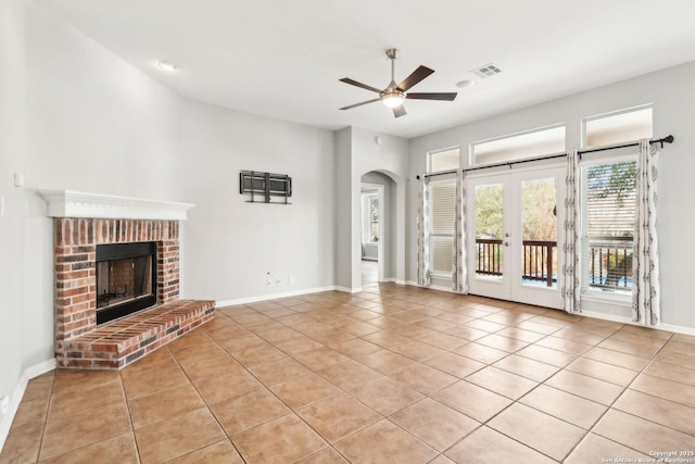 unfurnished living room with light tile patterned floors, ceiling fan, a fireplace, and visible vents