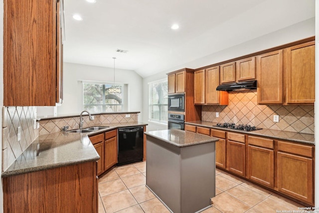 kitchen featuring brown cabinetry, a peninsula, under cabinet range hood, black appliances, and a sink