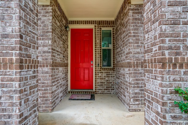 entrance to property featuring brick siding