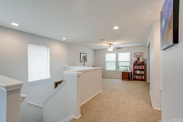 hall with recessed lighting, light carpet, visible vents, baseboards, and an upstairs landing