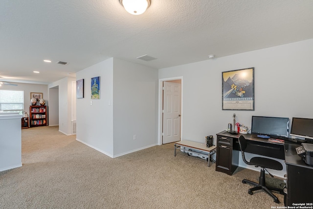 office space featuring a textured ceiling, carpet floors, visible vents, and baseboards