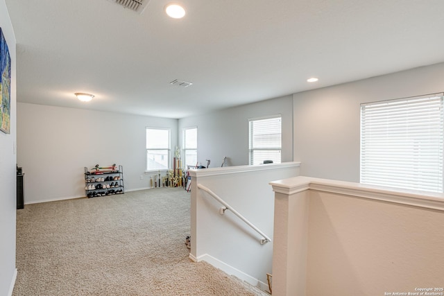 corridor with visible vents, baseboards, an upstairs landing, carpet floors, and recessed lighting