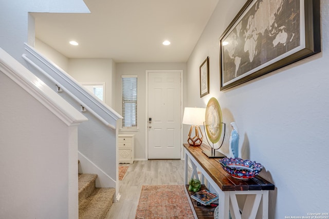 foyer entrance with light wood-type flooring, baseboards, recessed lighting, and stairs