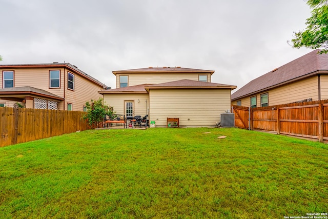 back of property with central air condition unit, a fenced backyard, a lawn, and a patio