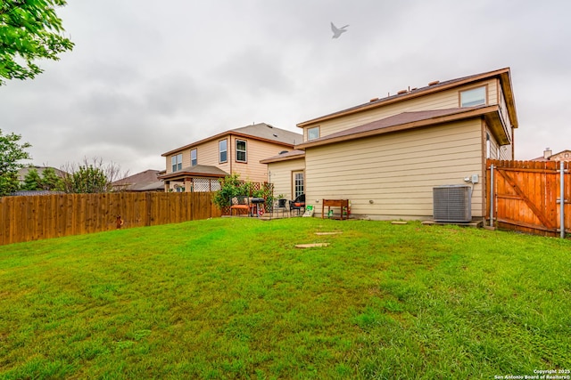 back of property featuring a yard, a patio area, a fenced backyard, and central air condition unit