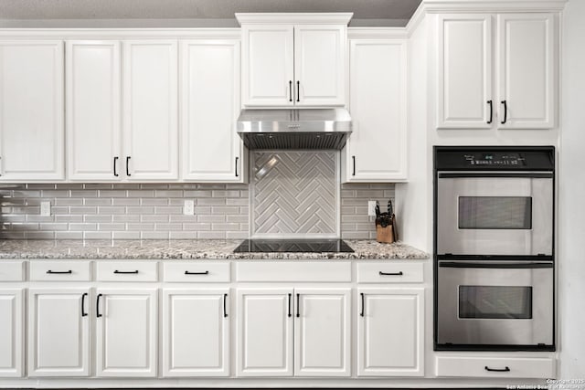 kitchen featuring decorative backsplash, black electric stovetop, stainless steel double oven, under cabinet range hood, and white cabinetry