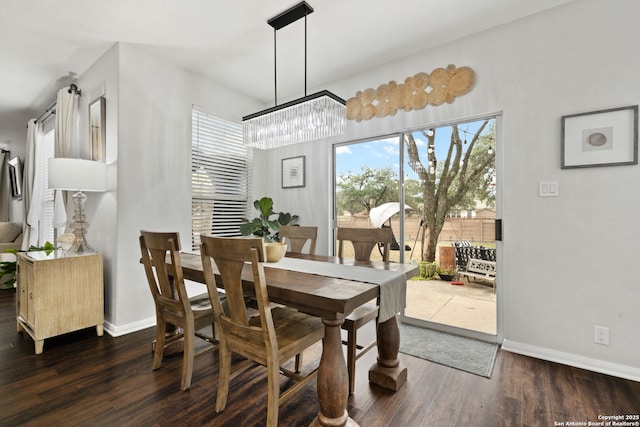 dining room featuring dark wood-style floors, plenty of natural light, and baseboards