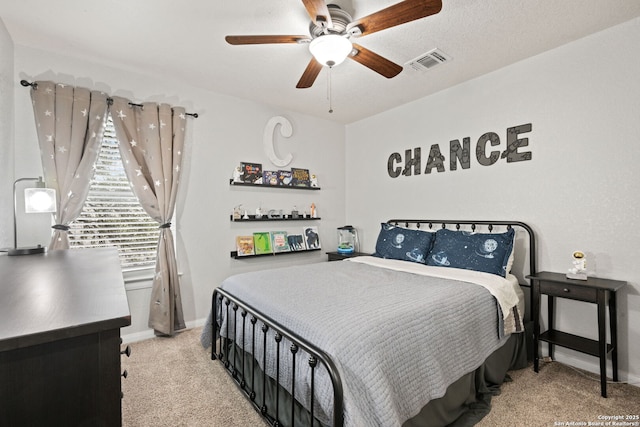 bedroom featuring baseboards, a ceiling fan, visible vents, and light colored carpet