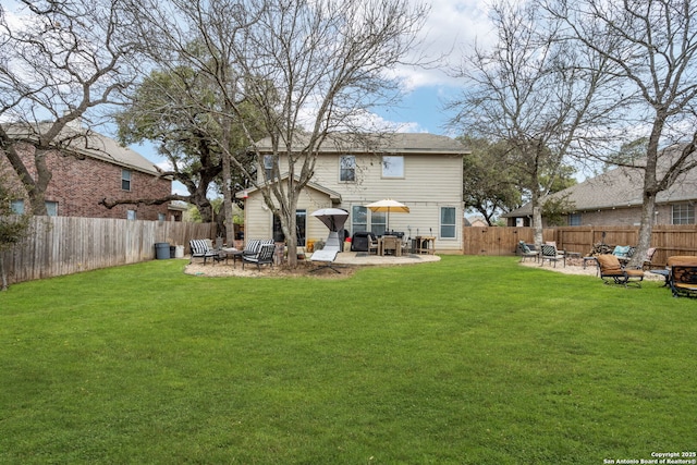 rear view of property featuring a yard, a fenced backyard, a fire pit, and a patio