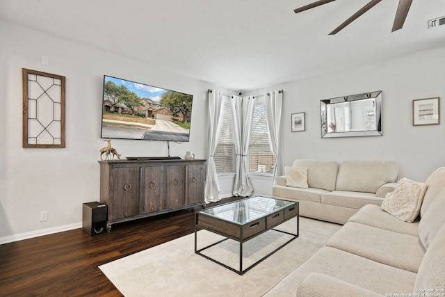 living area with a ceiling fan, wood finished floors, visible vents, and baseboards