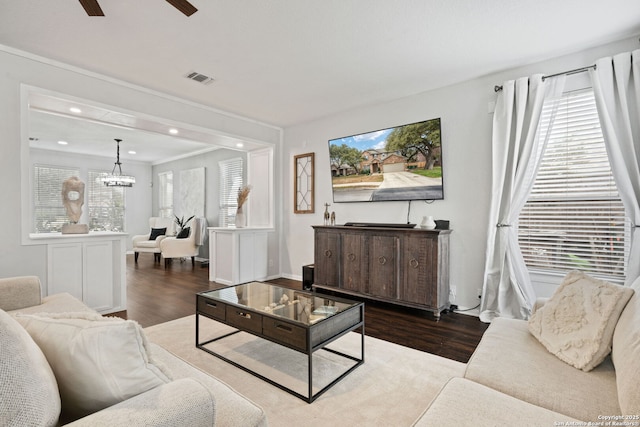 living area with crown molding, recessed lighting, visible vents, wood finished floors, and ceiling fan with notable chandelier