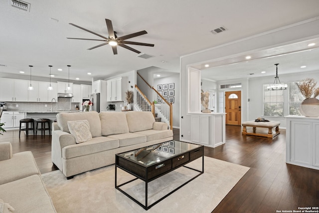 living area with stairs, wood-type flooring, and visible vents