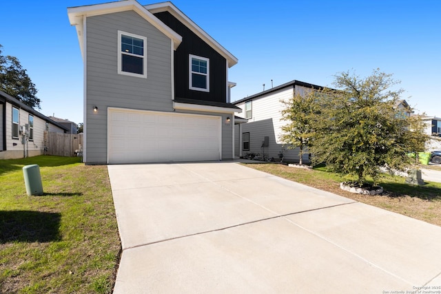 view of front of property with a front yard, concrete driveway, and an attached garage