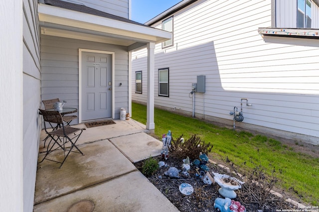 property entrance with a yard and a patio