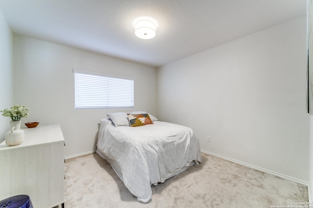 bedroom featuring baseboards and light colored carpet