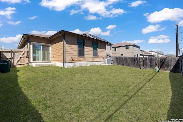 view of side of home featuring central AC unit, a yard, and a fenced backyard