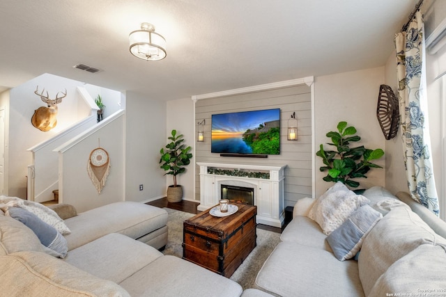 living area featuring stairs, a fireplace, and visible vents