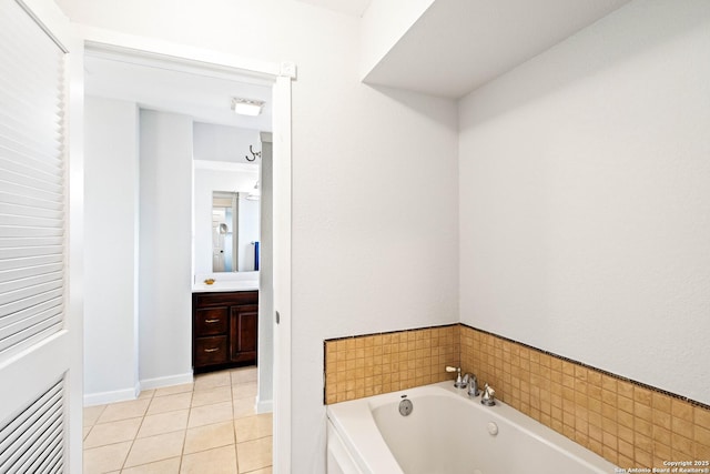 bathroom featuring tile patterned flooring, baseboards, vanity, and a whirlpool tub