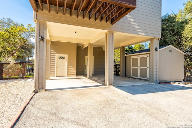 garage with a carport, a shed, and fence