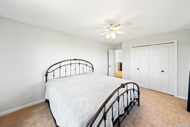 bedroom with light carpet, a ceiling fan, baseboards, and a closet