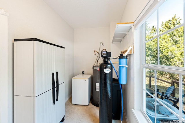 clothes washing area with light tile patterned floors