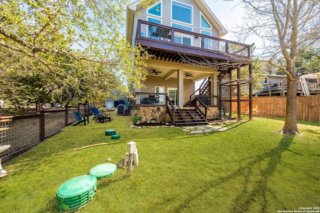 rear view of house featuring a lawn, central AC unit, a ceiling fan, a fenced backyard, and a wooden deck