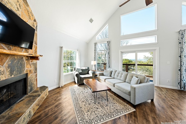 living area featuring baseboards, a fireplace, visible vents, and wood finished floors