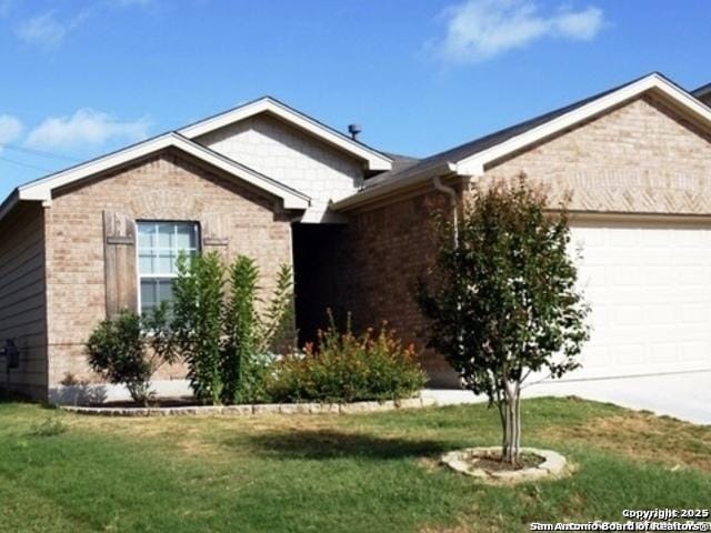 single story home with an attached garage, brick siding, driveway, and a front yard