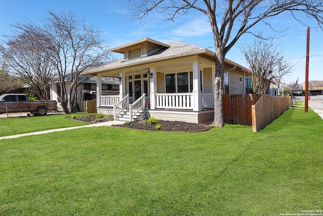 bungalow featuring a front lawn, fence, and a porch