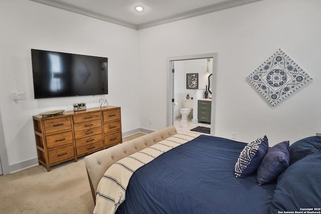 bedroom featuring crown molding, baseboards, ensuite bathroom, and light colored carpet