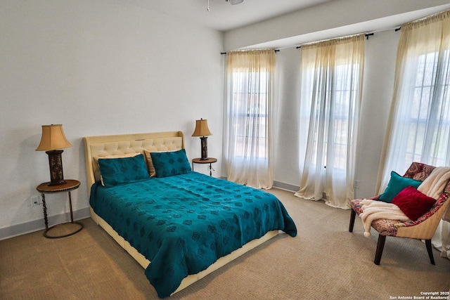 bedroom featuring carpet, multiple windows, and baseboards