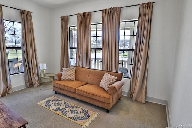 carpeted living area with baseboards