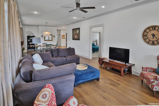 living room featuring light wood finished floors, recessed lighting, ornamental molding, baseboards, and ceiling fan with notable chandelier