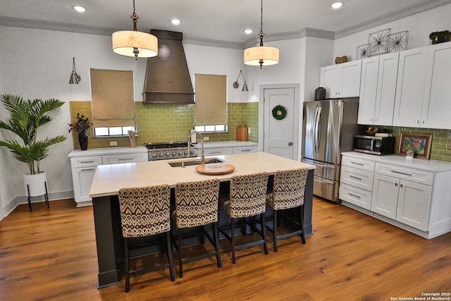 kitchen with dark wood-type flooring, custom exhaust hood, stainless steel appliances, light countertops, and a sink