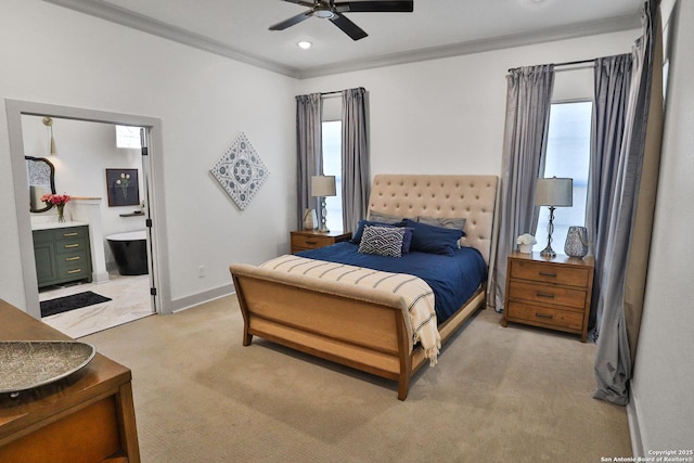 bedroom featuring ensuite bathroom, light colored carpet, a ceiling fan, baseboards, and ornamental molding