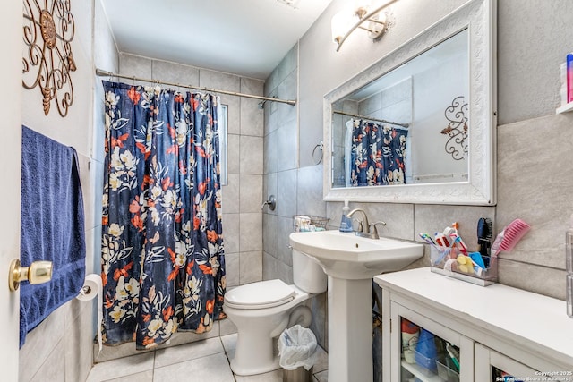 full bath with tile walls, tasteful backsplash, toilet, a tile shower, and tile patterned floors