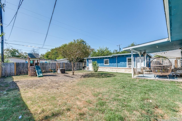 view of yard featuring a patio area, a fenced backyard, and a playground