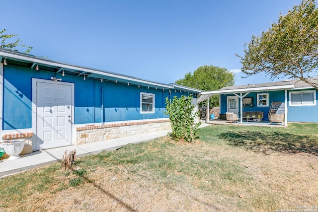 ranch-style home with a front yard and a patio area